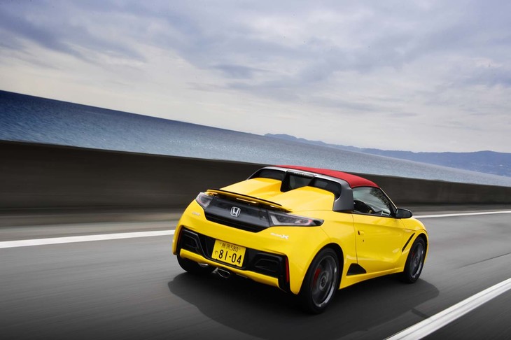 海辺の高速道路を行く「S660モデューロX」。ボルドーレッドのルーフも同モデルならではの装備のひとつ。