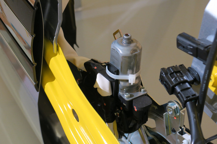 「軽自動車ではこれが初採用」という助手席イージークローザーのモーター。上下2カ所のロック機構を、ひとつのモーターで操作するという。