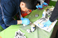 「モノづくり体験」コーナーでのメダル製作の風景。金属のメダルに自身の手でハンドプレスを行い、最後に磨き上げるというもの。隣では、レザー素材のキーホルダーに型押しするコーナーも用意されていた。