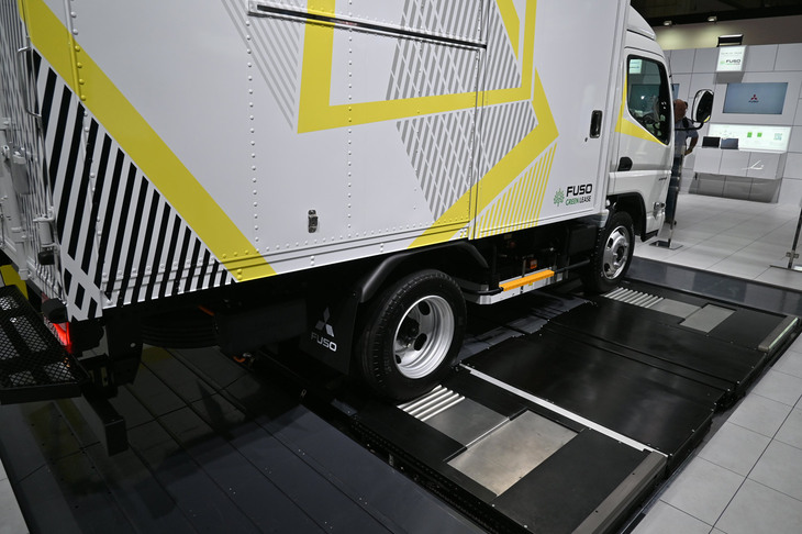 「三菱ふそうeキャンター」（バッテリー交換式モデル）と、バッテリー交換ステーション。