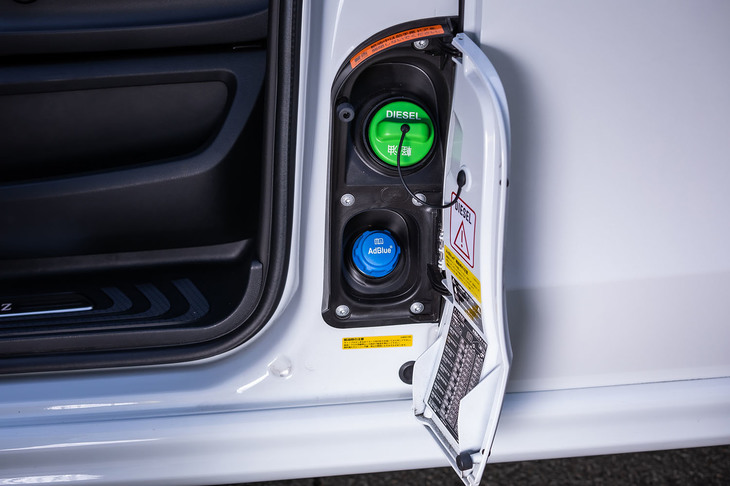 フューエルリッドは、助手席ドアと助手席側スライドドアの間に設けられている。緑色のキャップが給油口、その下方に見える青いキャップが尿素水溶液「アドブルー」の補充口。