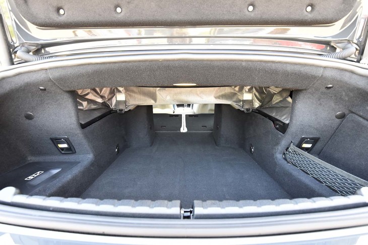 ほろを上げ、50：50分割式の後席を前方に倒して最大化した状態の荷室。後席のロック解除レバーは、左右両サイドにひとつずつ配される。