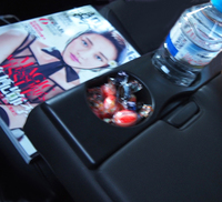 ブレがひどくて恐縮だが、後席アームレストの様子。ミネラルウオーター、キャンディー（ふたの中にはチョコも）、そして今朝まで乗車していたというモデルが表紙を務める『マリ・クレール』中国版。