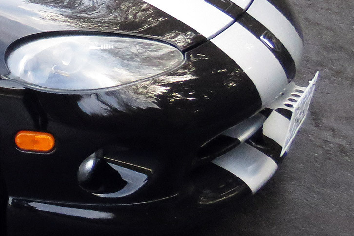 在りし日のナンバーステーがこちら。購入前のわが「バイパー」は、取り締まり対策（？）でフロントナンバーが下を向いており、その都合でナンバーステーがかなり突き出ていた。今はもう、こんな出っ歯ではありません。