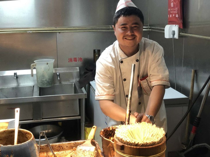 こちらは「王府井小吃街」で。臭豆腐売りのおじさん。このエリアそのものには自転車の乗り入れはできないが、シェアリング自転車登場で、近くまでのアクセスは従来に比べて格段に良くなったはず。