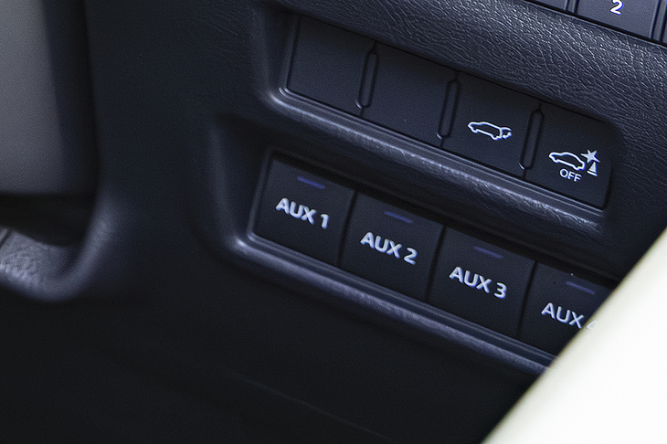 ステアリングホイールの右側には1～4までのAUXスイッチを装備（“オーバートレイル＋”専用）。後付けの補助灯などを操作する目的であり、アースを通した取り付けコネクターがヘッドランプの下部に備わっている。