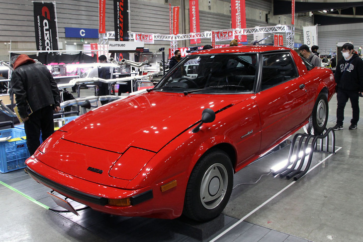 フジツボが展示していた初代「マツダ・サバンナRX-7」（SA22C）。フェンダーミラーにオムスビ（ロータリーエンジンのローター）をかたどった純正アルミホイールがイカしてる。