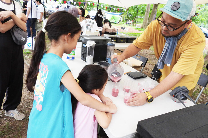 子どもたちにスムージーを配る『＆GP』のスタッフ。