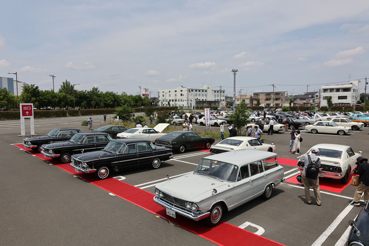 88台が集まった会場風景。レッドカーペット上に並べられたのは、今年誕生60周年を迎えた2代目「プリンス・グロリア」（S40）、そして50周年を迎えた2代目「日産ローレル」（C130）と4代目「日産スカイライン」（C110）。いずれも村山工場でつくられたモデルで、ローレルとスカイラインは基本設計を共有するいわば兄弟車である。