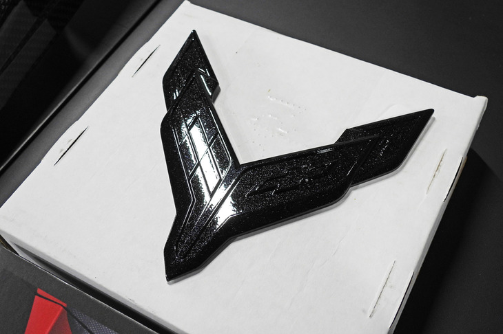 カーボンファイバーメタリック仕上げの“クロスフラッグ”エンブレム。