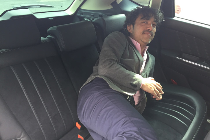 高級感あふれる「デルタ」の後席に、体を預ける塩見氏。ぜいたくなしつらえが気に入った様子。