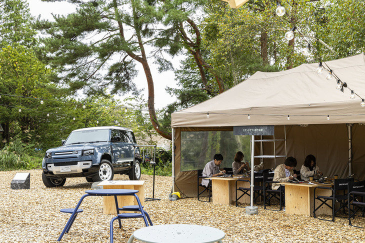「DESTINATION DEFENDER POP-UP IN KARUIZAWA」の会場風景。日によって異なるアクティビティーやワークショッププログラムが用意されていた。奥に見える展示車両は「タスマンブルー」の外板色をまとった「ディフェンダー110 SEシティパック」。
