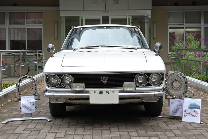 「群5」のシングルナンバーを付けた1969年「マツダ・ルーチェ ロータリークーペ」。マツダのロータリーエンジンで唯一ローターハウジングが大きい13A型エンジンを積んだ、マツダ初にしてロータリーではこれっきりとなるFF車。大きさの違いがわかるよう、車両右側にその13A、左側に12Aのローターハウジングを展示していた。ちなみに10A、12A、13Bはローターハウジングの大きさは同じで、厚みを変えて排気量を増減。3ローターの20Bも13Bの個数を増やしている。
