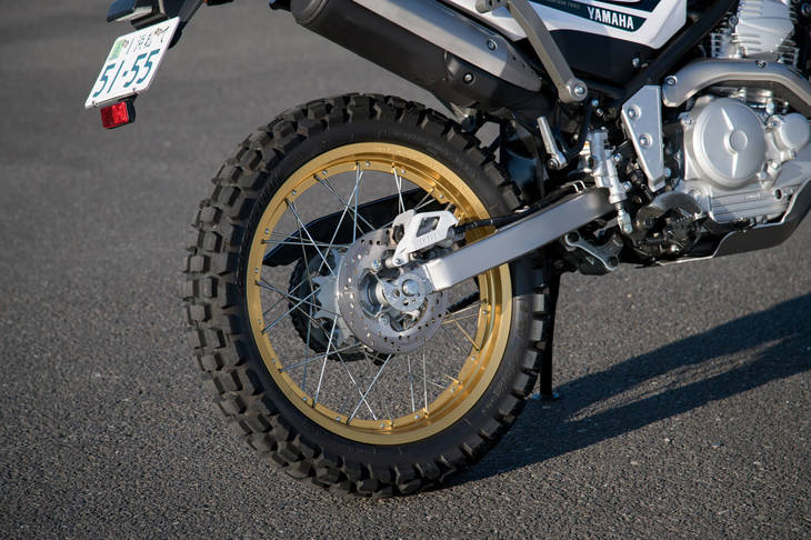 リアサスペンションは軽量アルミ製シリンダーのボトムリンク式。フロント21インチ、リア18インチのスポークホイールに組み合わされるタイヤは、悪路と舗装路の両方の走行を想定した専用品となっている。