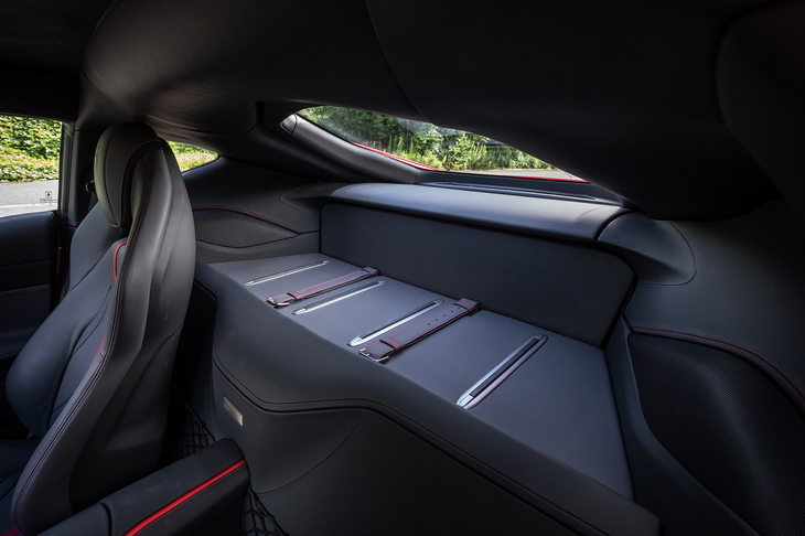 シート背後にフラットなラゲッジスペースを持つ。赤いステッチを採用する荷物を留める本革製のベルトも装備している。