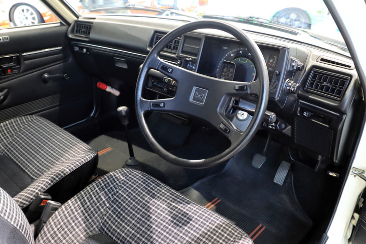 初代とは打って変わって、直線と四角で構成されるインストゥルメントパネルまわり。メーターまわりに備わるバイザースイッチや、足元スペースを広く取るべく下部がえぐられた助手席側ダッシュボードの形状も目を引く。