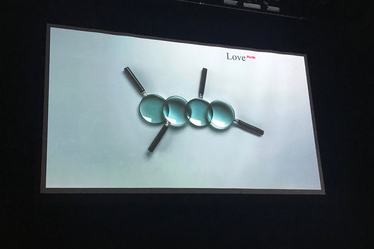 和田氏が登壇時に用いられた画像。虫眼鏡を組み合わせ、アウディのエンブレムが表現されている。