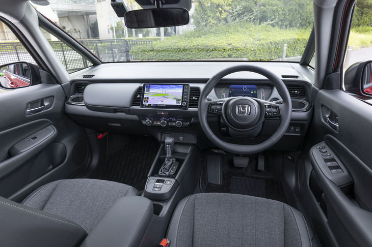 ステアリングホイールやシフトセレクター、カップホルダーのピアノブラック加飾が「ブラックスタイル」ならではのポイント。最新のホンダ車に共通の無印良品的なインテリアの初出は「フィット」だった。