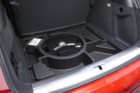 「RS Q3」にはBOSEのサラウンドサウンドシステムが標準で組み込まれる。その構成要素であるウーファーは、荷室のフロア下（写真中央）に配される。左奥は、パンク時などに用いるタイヤの空気入れ。