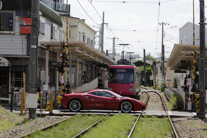 世田谷線と交差する「488GTB」。フェラーリはエンジンのターボ化や独自のアイドリングストップ技術「HELLE」で燃費向上に対応する。（photo：北畠主税）