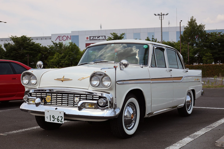1962年「プリンス・グロリア」。まだ小型乗用車（5ナンバー）の排気量の上限が1.5リッターだった1959年に、5ナンバーフルサイズセダンだった初代「スカイライン」の内外装を高級化して1.9リッター直4エンジンを積んだ、戦後型としては初の本格的な3ナンバーの普通乗用車として登場した初代グロリアの最終型。白いボディーカラーはノンオリジナルだが、まるで新車のように仕上げられた希少車。