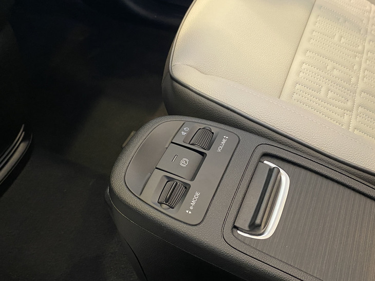 運転席・助手席間には、運転モード（3段階）の切り替え用とパーキングブレーキ用、オーディオ音量の調節用スイッチが。