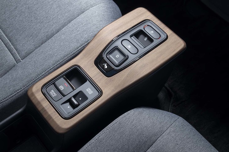 ダッシュボードと同様、センターコンソールも優しい色合いのウッド調パネルとマットな樹脂パーツで仕立てられる。シフトセレクターはボタン式。
