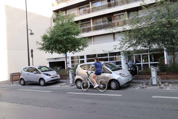 「オトリブ」用ステーションの前を、「ヴェリブ」のシェア自転車に乗った人が行く。一時はこれが未来の図だと思ったものだ。2017年にパリで撮影。