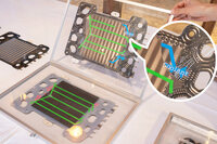 「セルのどこをナニが通っているか」を説明するために、ホンダが用意した“本”状の模型。こちらは水素極側の様子で、電極集合体とセパレーターの間を水素（緑のバー）が、セパレーターの内部を冷却水（青いバー）が通過しているのがわかる。