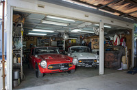 20年前に建てられた阪本さんのガレージ。ホンダの“エス”を整備し修理し改造するためのスペースである。現在の“エス”は、赤の「S800ロードスター」（RSCのハードトップを付けたカフェレーサー風）と白の「S800クーペ」、そして取材時はイベント参加のため不在だった青のS800クーペ（レーシング仕様）の3台。「CB72」「CL72」など3台のバイクも同居している。