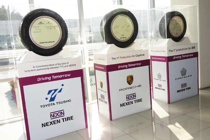 ロビーには「ポルシェ・カイエン」向けに納入される純正装着用タイヤの生産第1号が展示されていた（中央）。