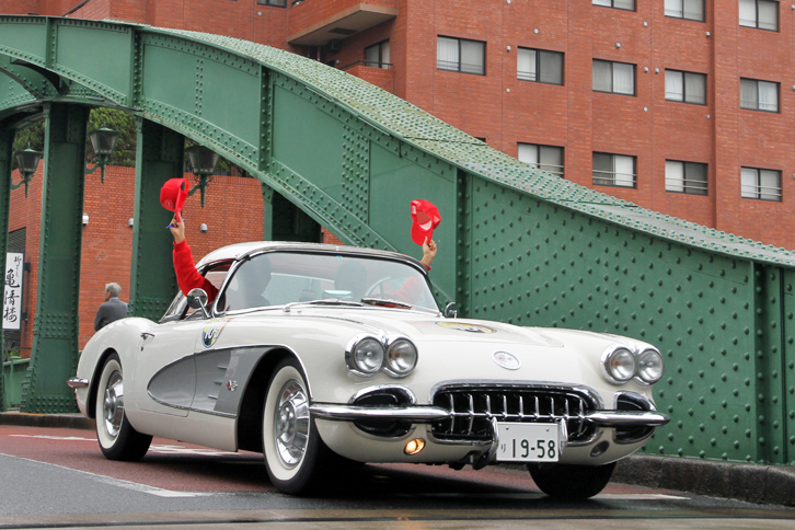 キャップを振ってスタッフに応える1958年「シボレー・コルベット」。