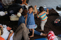 ハンガリー東駅の地上と地下鉄を結ぶコンコースで。家族とともに過ごす難民の少女が、筆者が向けるレンズに手を振った。
	 