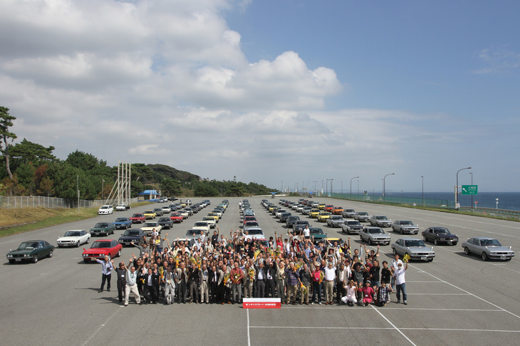 「いすゞ117クーペ生誕50周年記念ミーティング」の参加者とゲスト全員による記念撮影。