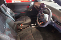 「MINIジョンクーパーワークスE」のインテリア。ブラックのリサイクルポリエステル表皮に赤いアクセントが入るダッシュボードが目を引く。