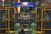 ロボットによる溶接の様子。一度に全ての部品を組み付けることはできないので、車体は人の手による仮組み付けのエリアと、ロボットによる溶接のエリアを2往復することとなる。
    