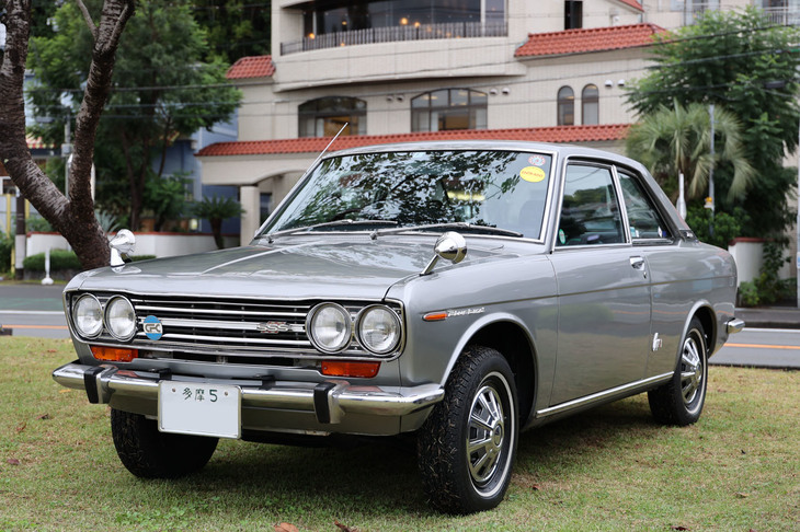 1969年「ダットサン・ブルーバード1600SSSクーペ」。「多摩5」のシングルナンバーで、キャップ付きのスチールホイールにホワイトリボンタイヤを装着。新車当時とほぼ変わらぬいでたちの、まるでタイムスリップしてきたかのような個体。
