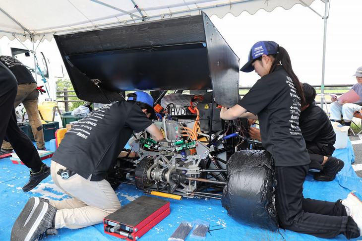 「学生フォーミュラ日本大会2023」でマシンを整備する名古屋工業大学EV。同校は省エネ賞2位、EVクラスのルーキー賞などを獲得した。リアスポイラーなどの空力部品の有無や形状はチームによって千差万別だが、大会関係者によると「近年はエアロパーツ装着マシンが上位に入る傾向にある」という。