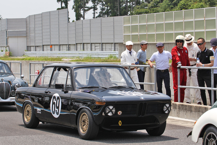 初開催されたセブリング 40m トロフィー。1950～69年に造られた量産サルーンとスポーツカーによる、ドライバー交代義務のある40分耐久レース。これに「クレイジーケンバンド」の横山 剣さんとレジェンドドライバーの桑島正美さんのペアが、“黒い稲妻”の異名をとった往年の桑島さんのマシンのように真っ黒に塗られた1971年「BMW 2002」で参戦した。コースインしようというファーストドライバーの桑島さんを、剣さんとチームクルーがピットウオールから見送る。