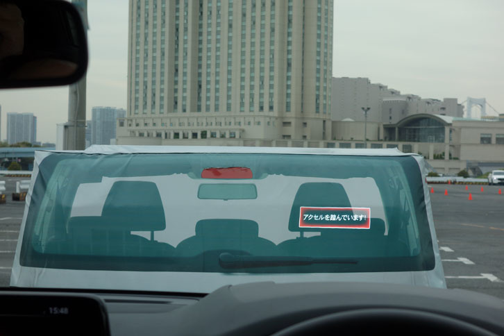 AT誤発進抑制制御の体験中。制御が作動すると、警告音が鳴るとともに、ヘッドアップディスプレイに「アクセルを踏んでいます！」と警告が表示される。