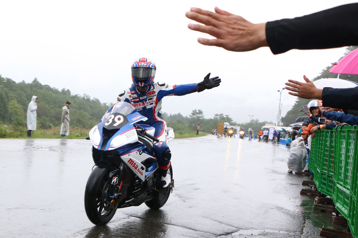 雨天のため、8耐マシンによるデモランは低速走行となったが、観覧者の近くをゆっくりと流し、ハイタッチをするなどのファンサービスが行われた。写真は「BMW Motorrad 39」チームの酒井大作選手。
