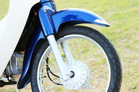 「スーパーカブ」の特徴のひとつである、優雅な意匠のサイクルフェンダー。サスペンションは非常にシンプルなテレスコピック式（前）とスイングアーム式（後ろ）の組み合わせだ。