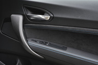 ドアハンドルはカーボン。アルカンターラのトリムには青いステッチが走る。