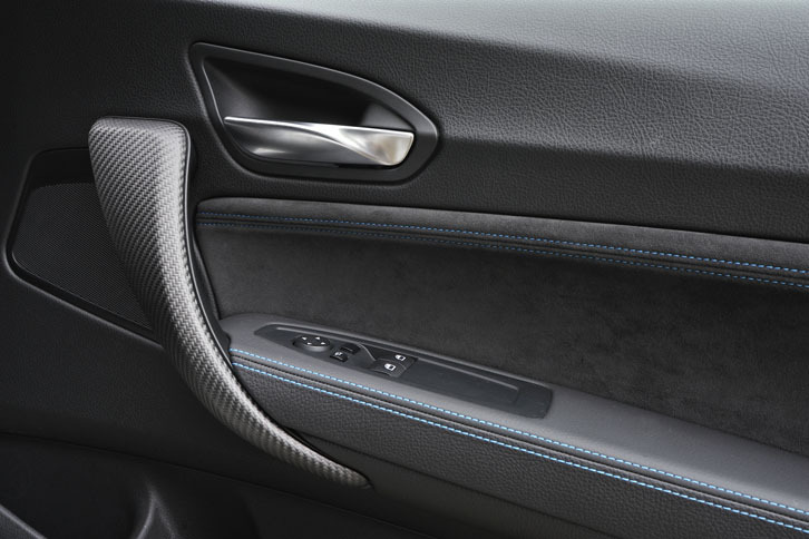 ドアハンドルはカーボン。アルカンターラのトリムには青いステッチが走る。