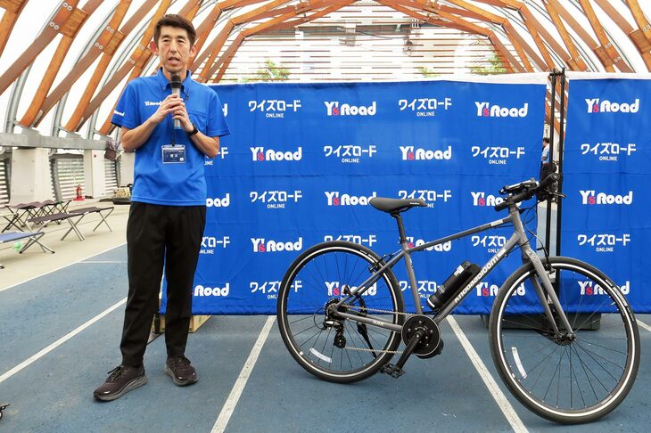 「スマチャリ」の特徴について説明する、ワイ・インターナショナルの青木亮輔マーケティング部部長。「RAIL ACTIVE-e」は後付け式の電動アシストシステムを装着した自転車として、業界で初めて日本交通管理技術協会の型式認定を取得した車両となる。