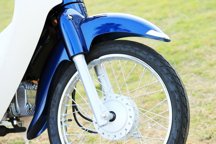 「スーパーカブ」の特徴のひとつである、優雅な意匠のサイクルフェンダー。サスペンションは非常にシンプルなテレスコピック式（前）とスイングアーム式（後ろ）の組み合わせだ。