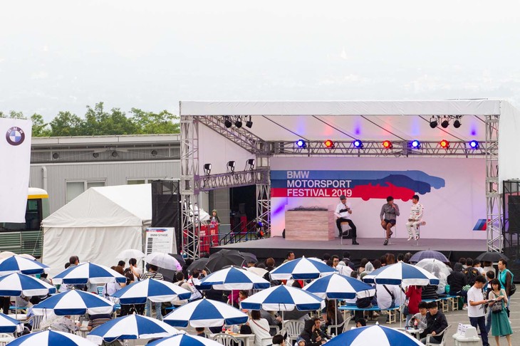 パドックに設置された特設ステージでは、レーシングタクシーなどの各種同乗走行の抽選会やゲストが登場するトークショー、DJによるステージパフォーマンスなどが終日行われ、大勢の観客を集めていた。