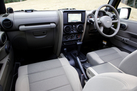 シート表皮は「スポーツ」とそれ以外で異なる。スポーツは布製バケットシートで、「サハラ」「ルビコン」は、泥などの汚れやニオイを残さない「Yes Essentialsプレミアムシート」が備わる。また、HDDナビゲーションシステムが標準装備されるのは「アンリミテッドサハラ」（写真）のみ。
    