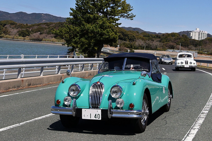 1956年「ジャガーXK140ロードスター」。左上方に見えるのが猪鼻湖。