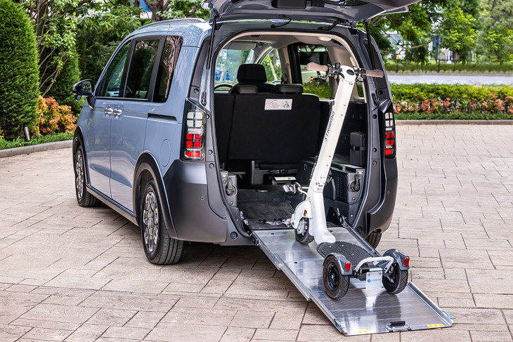 車いすなどの積載に対応する「フリード クロスター スロープ」に、電動の立ち乗り三輪モビリティー「ストリーモ」を搭載する様子。スライド式の「スーパーフレックススロープ」と、速度調整と進路補正機能が付く電動ウインチによって、こうした車両も手軽に収容できる。